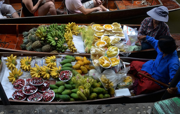 Floating market with produce sold from small boats in Thailand.