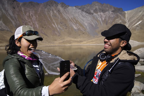 Hikers standing next to the lake in the crater of the extinct volcano