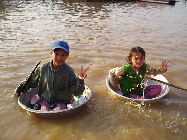 Industrious kids collecting plastic and cans on the Mekong River.