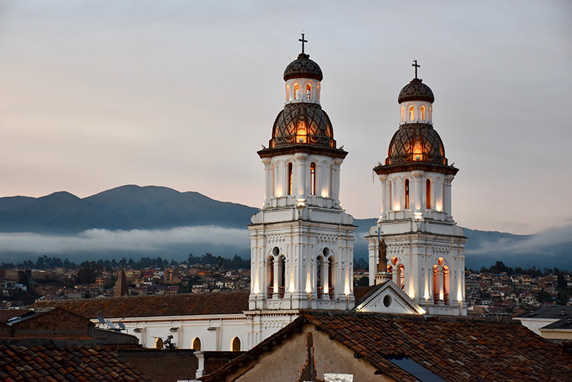 The towers of the Santa Domingo church with a Cuenca skyline in the background
