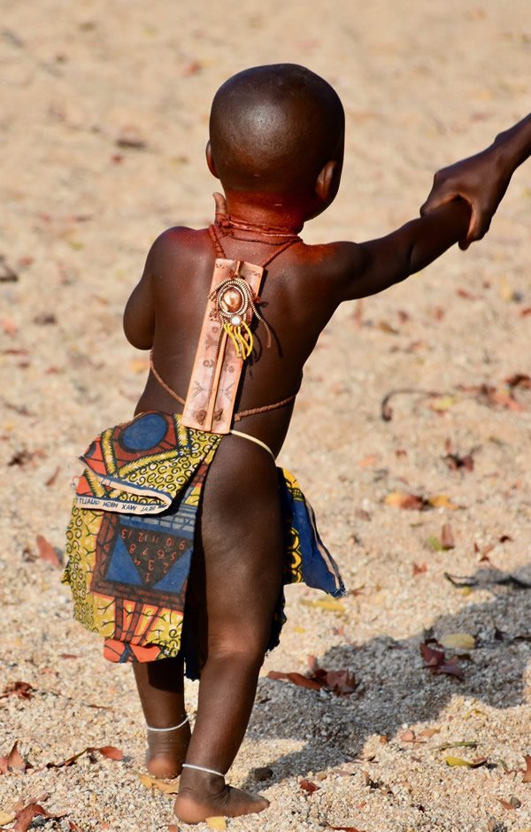 Mucubal baby boy with wooden talisman on his back