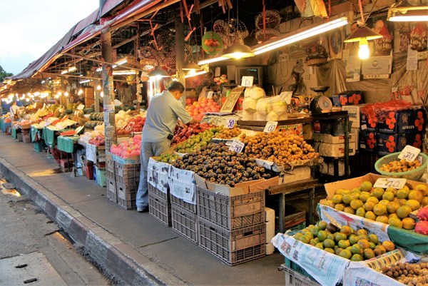 A man with his produce at a night market in Chiang Mai