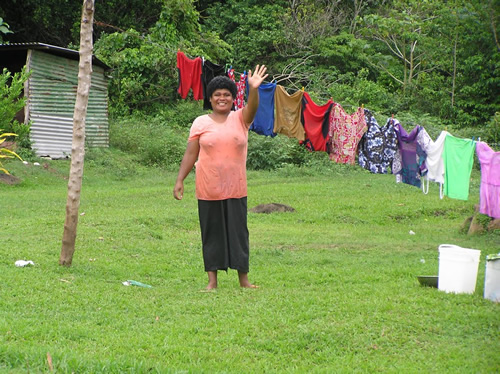 Women waving from her backyard in Fiji.