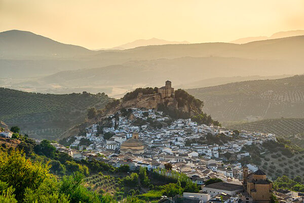 Old Granada with houses winding up the hill topped by a church.