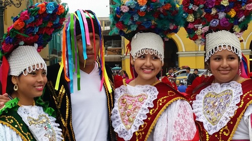 A colorful parade with young women and a man dressed up in Lima, Peru
