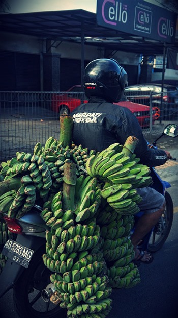 A scooter loaded with bananas.
