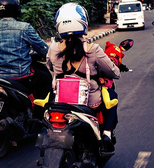 Driving scooter in Bali, mother and child.
