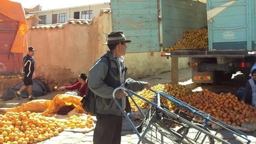 Men unloading thousands of oranges off a truck in Sucre, Bolivia.