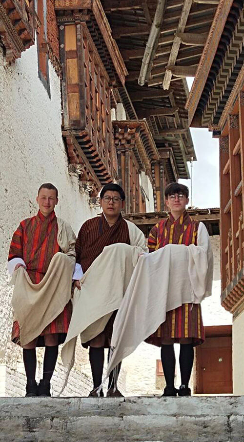 Owen and Archie standing with Lopen Tshewang, their Vice Principal and cultural expert.