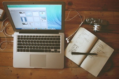 Travel writer tools, such as a notebook, computer, and camera.