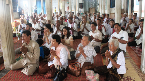 Cambodian Buddhist worshippers praying during a ceremony.