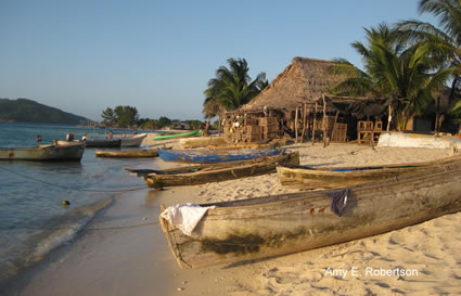 Canoes sitting on beach by a lake in Honduras.