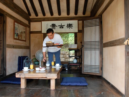 Observe local customs by eating breakfast on a porch hanok.