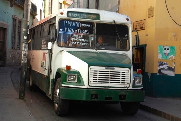 bus making its way through a narrow, curvy street in Guanajuato.