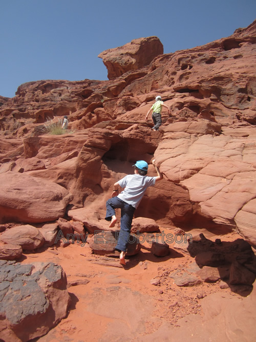 Climbing over rocks in Wadi Rum desert, Jordan.