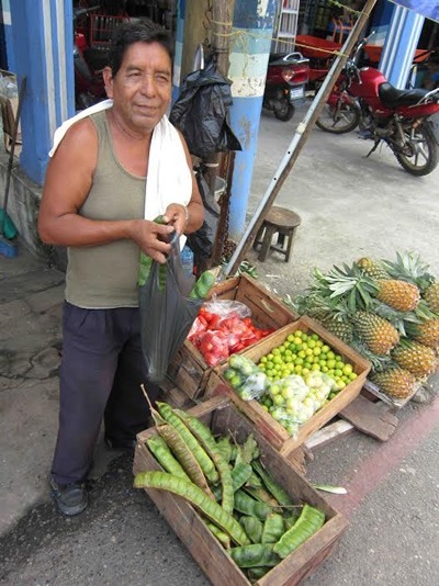 Man with paterna fruit at a market in Mexico.