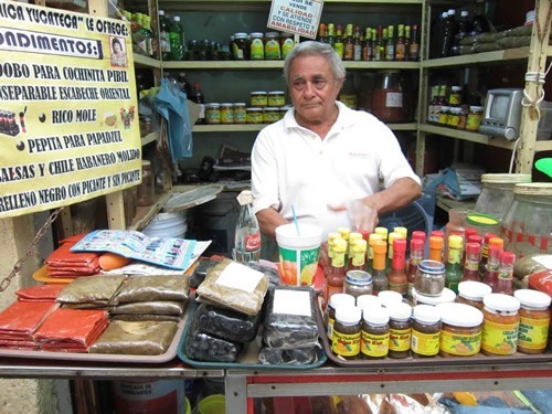Man selling spicy peppers in his stall at a market in Mexico