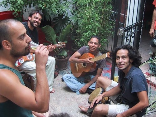 Author staying in a hostal in Latin America solo, playing guitar with other men.