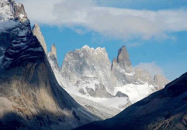 Hiking in a valley through the jagged rock mountains covered with some snow in Patagonia, Argentina.