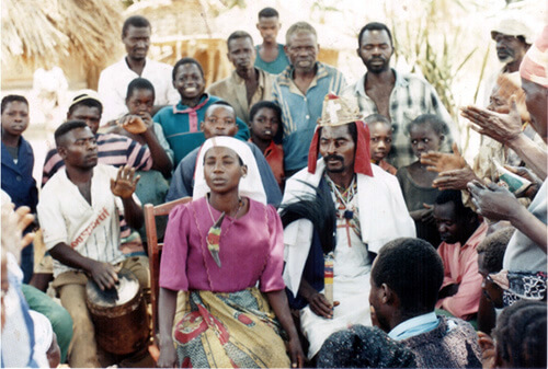 Woman in purple sitting in the group during exorcism in Zambia.