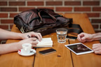 Two people sitting at wood table netoworking for work thumbnail.