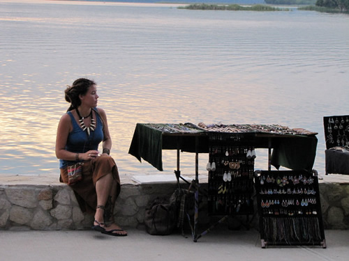 An artisan sits selling jewelry in Flores, Guatemala.