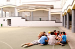 Children in schoolyard in Spain gathered around teacher thumbnail