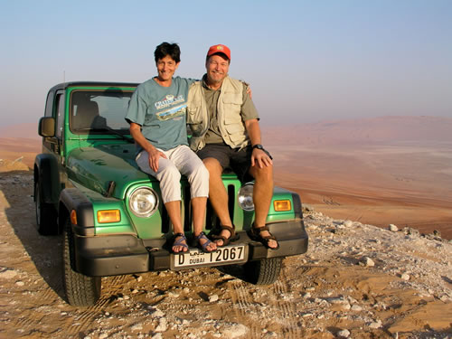 International teachers visiting sand dunes with 4x4 truck.