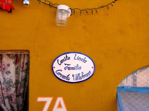 Volunteers in Mexico build new house with name of owner on plaque.