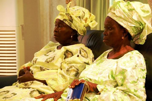 Matrons from the king's court listen at the forum.