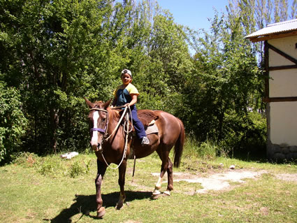 Little Gaucho riding a horse at the farm in Argentina.