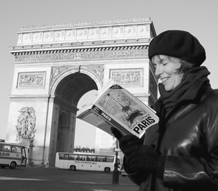 Women reading a guidebook in Paris, France in front of the Arc de Triomphe.