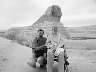 Lynn Atkinson in her wheelchair with her friend Leo in front of the Sphinx in Giza, Egypt.