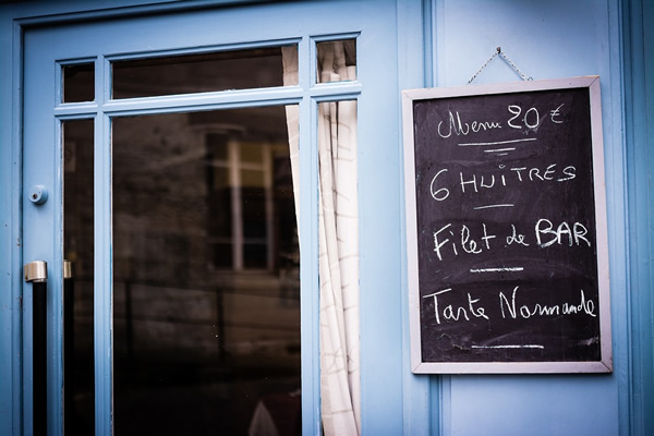 A French menu displayed outside a restaurant door in France.