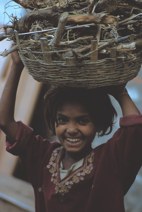 A young girl carrying a basket of wood in Nepal.